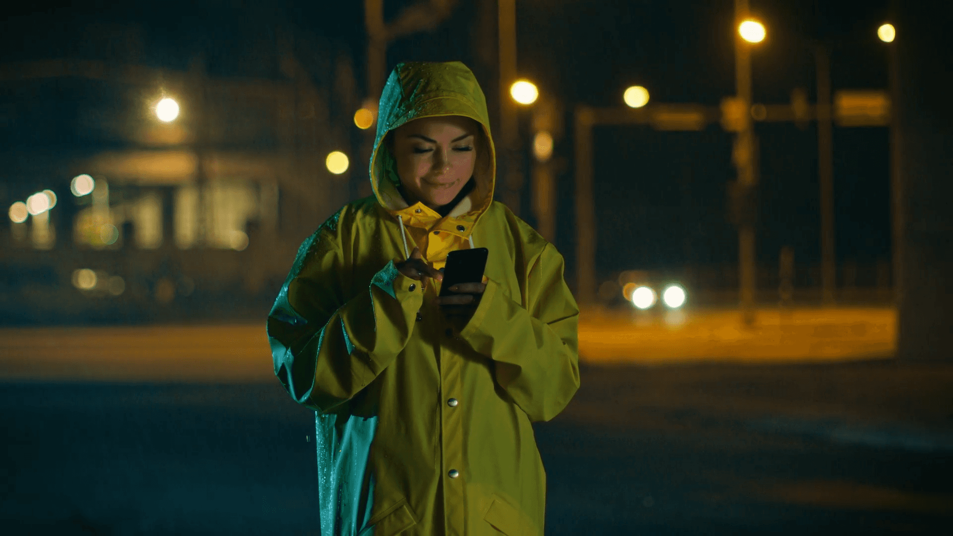 Person mit Smartphone erhält nachts eine Starkregen-Frühwarnung